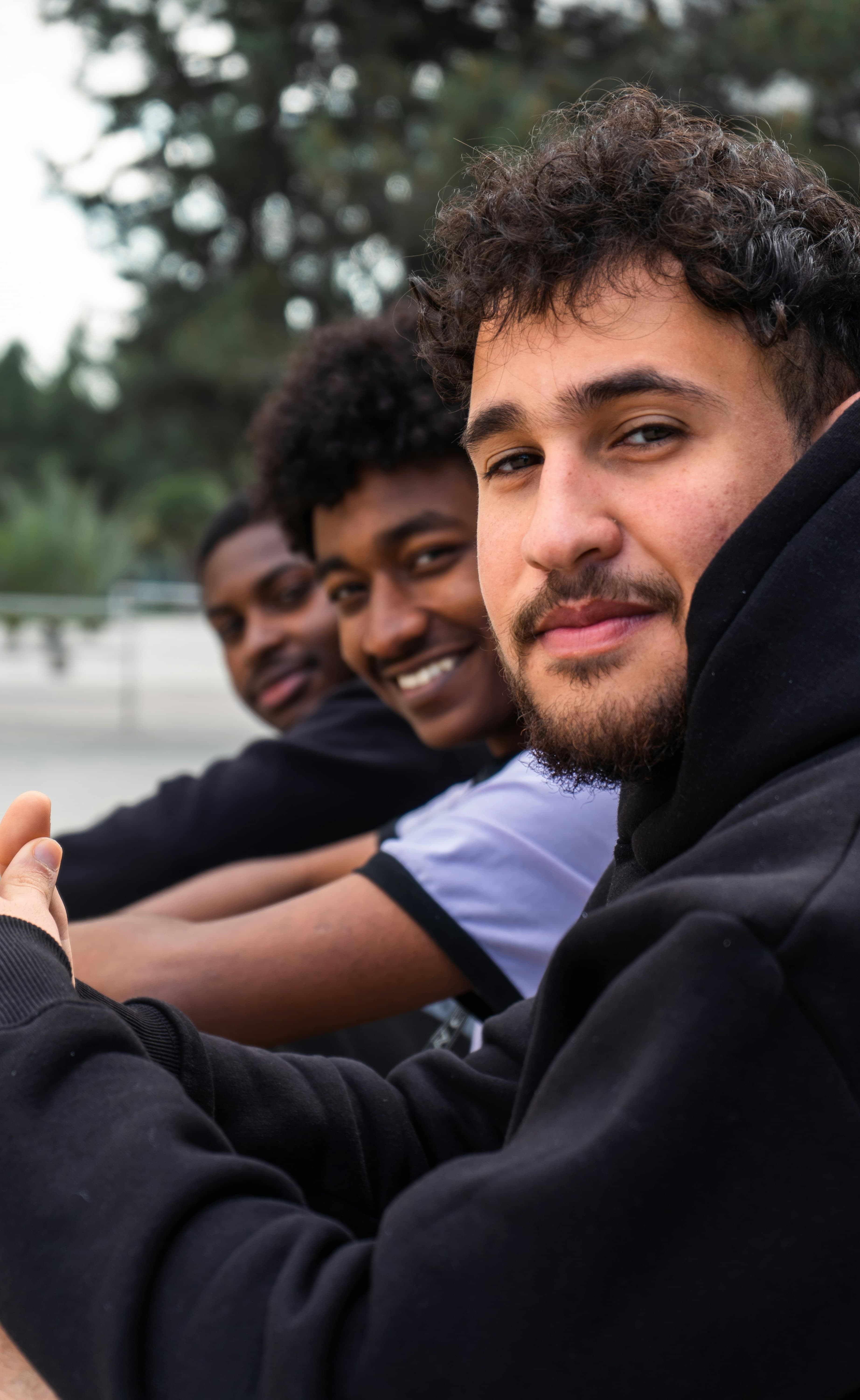 A group of young men sitting side by side, talking
